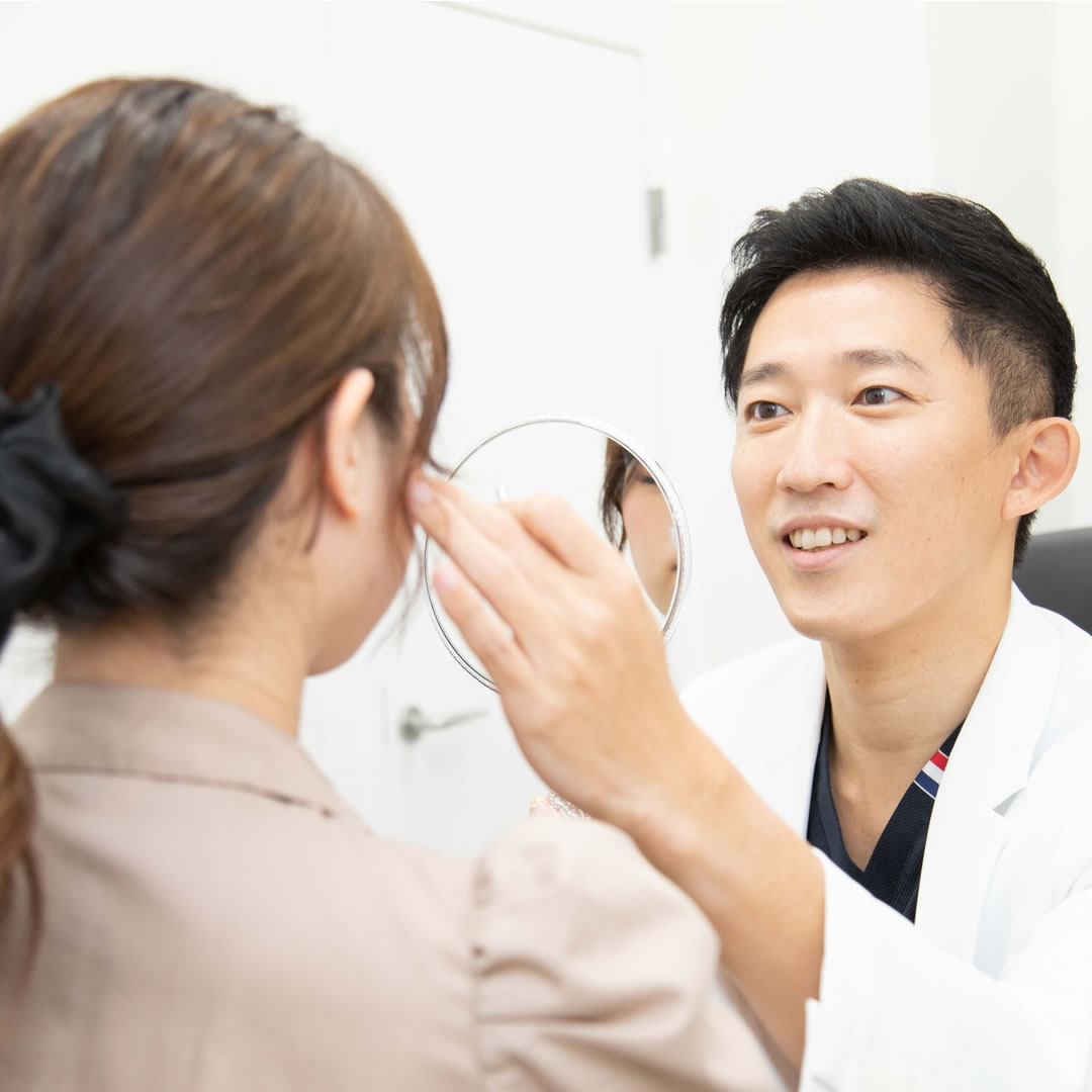 顔の脂肪吸引後のマッサージの注意点を説明する医師